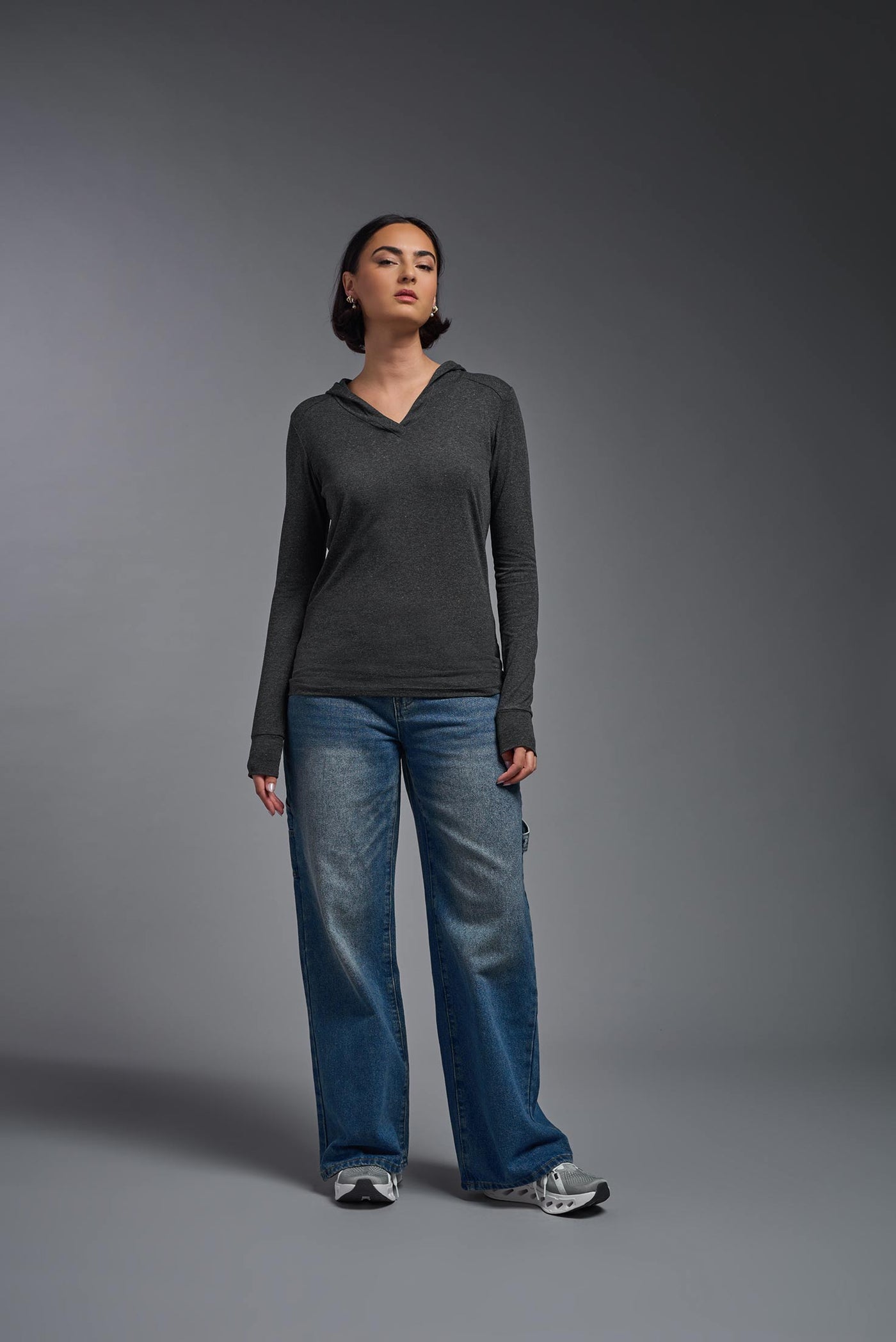 A female model wearing the women's Heather Hoodie Shirt in the color dark heather charcoal, showing the modern fit from a front view. This hoodie shirt is made in the USA. #color_dark-heather-charcoal