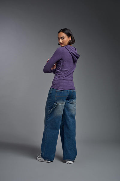 A female model wearing the women's Heather Hoodie Shirt in the color dark heather purple, showing the modern fit from a back view. This hoodie shirt is made in the USA. #color_dark-heather-purple