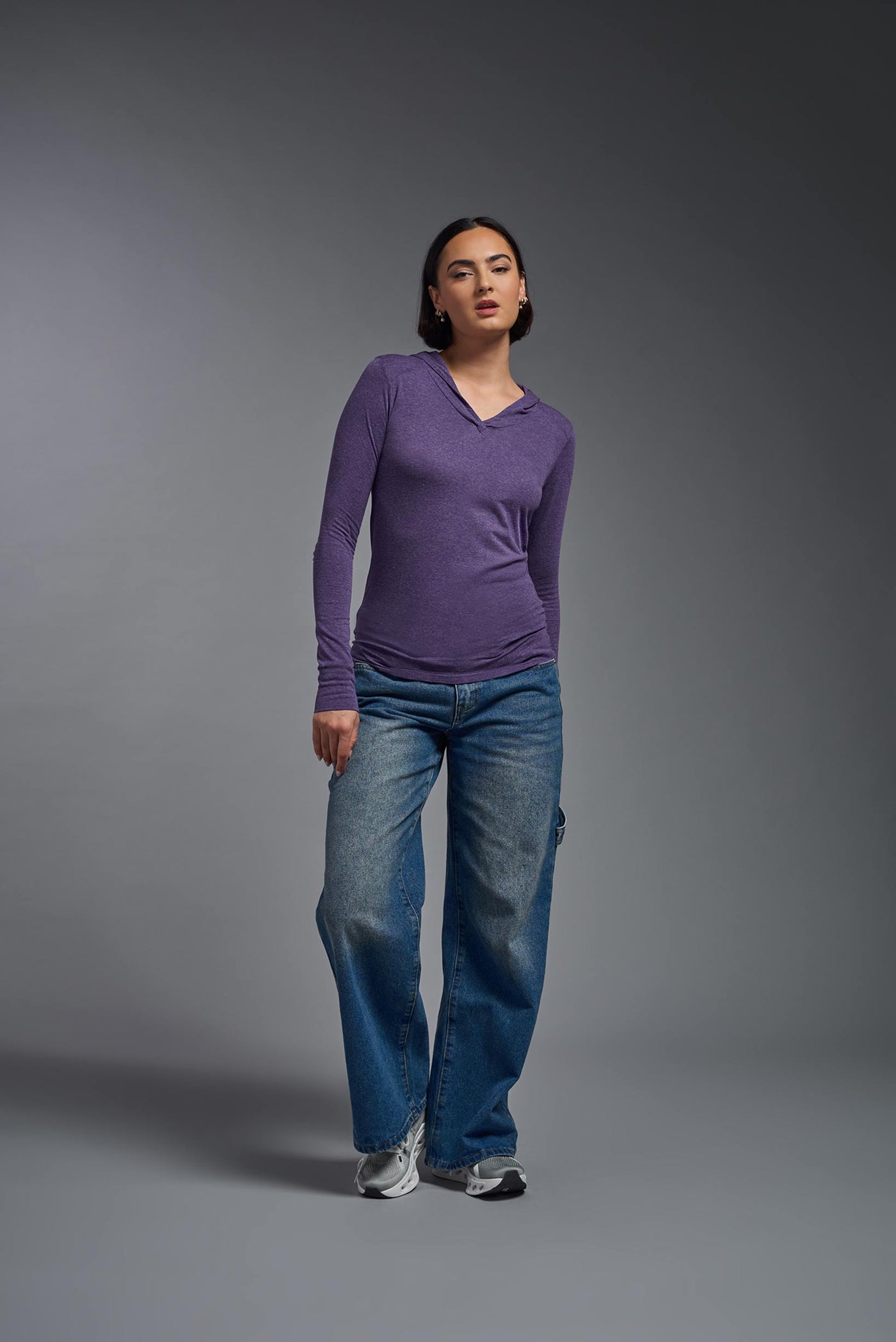 A female model wearing the women's Heather Hoodie Shirt in the color dark heather purple, showing the modern fit from a front view. This hoodie shirt is made in the USA. #color_dark-heather-purple