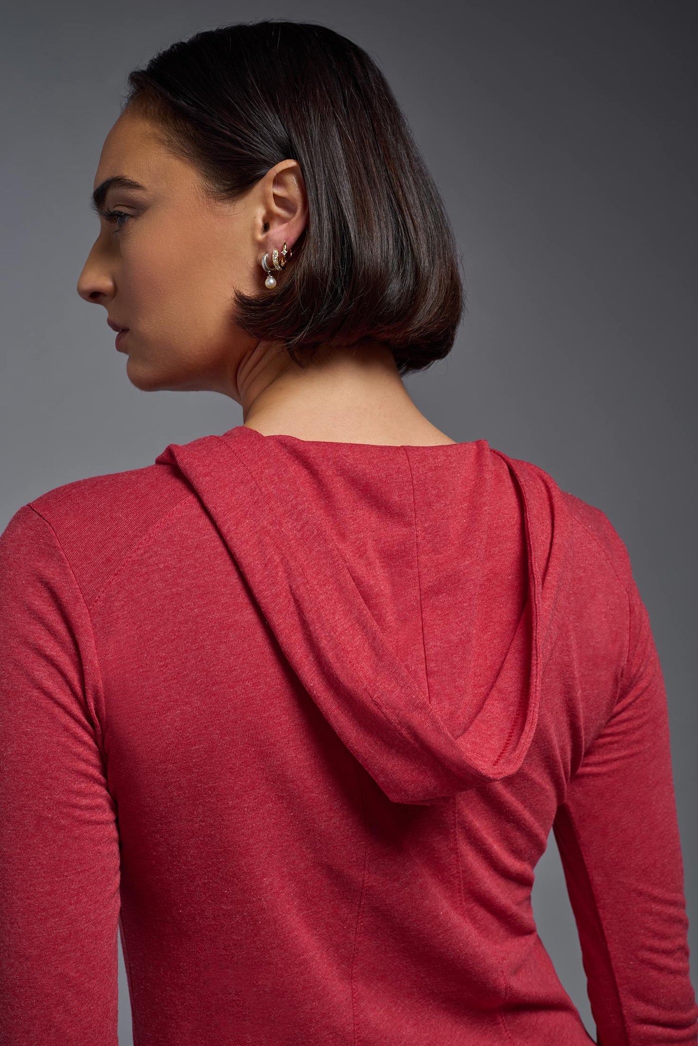 A female model wearing the women's Heather Hoodie Shirt in the color dark heather red, showing the modern fit from a closeup hoodie back view. This hoodie shirt is made in the USA. #color_dark-heather-red