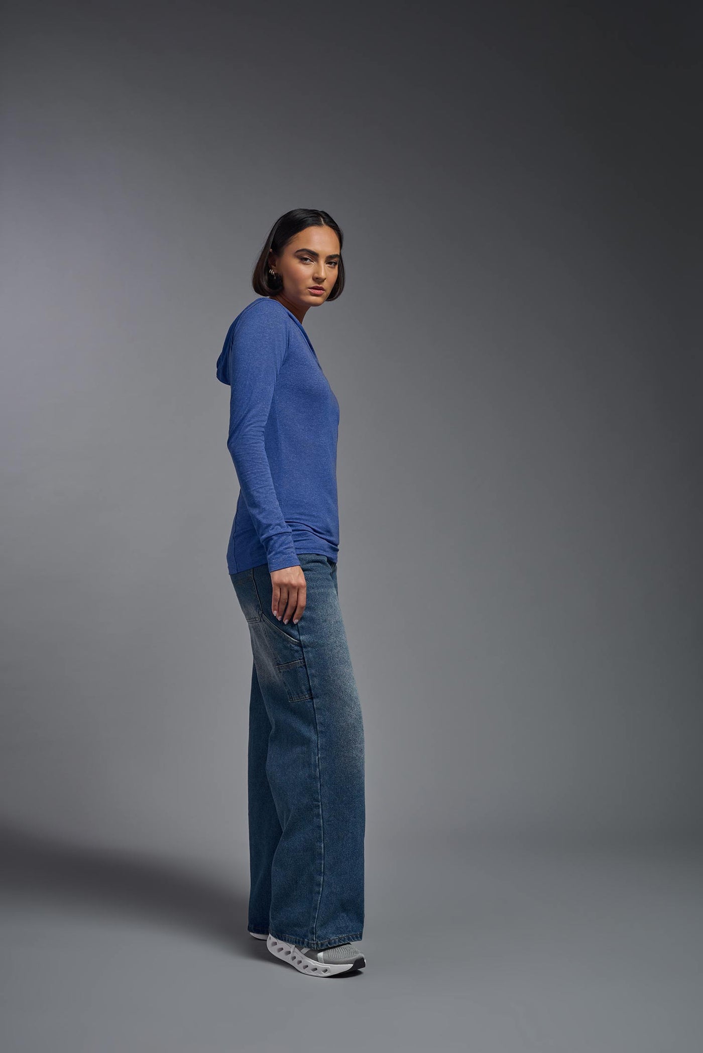 A female model wearing the women's Heather Hoodie Shirt in the color dark heather royal blue, showing the modern fit from a closeup hoodie side view. This hoodie shirt is made in the USA. #color_dark-heather-royal