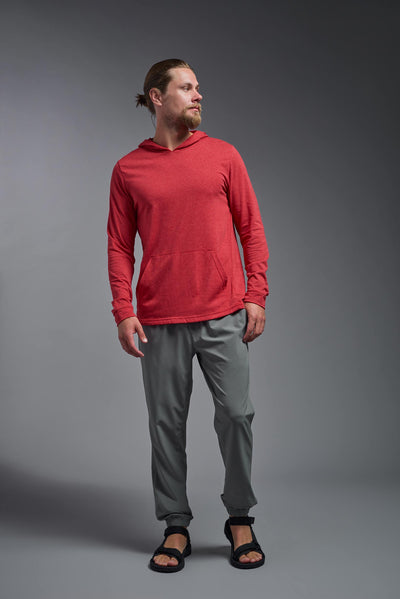 A blonde male model with a beard on a gray background, wearing the men's Heather Hoodie Shirt in the color dark heather red, made out of 88% polyester and 22% treated cotton, showing the relaxed fit from a front view. This hoodie shirt is comfortable and made in the USA. #dark-heather-red