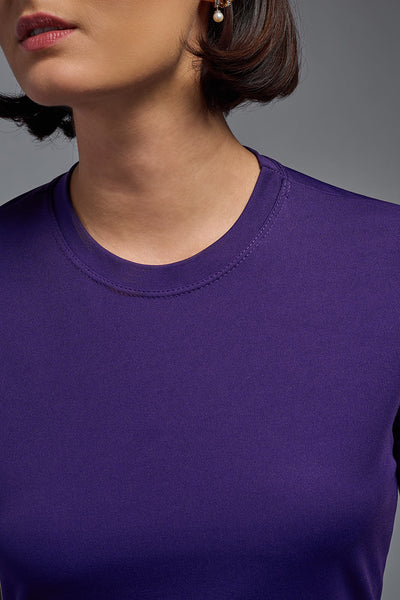 A female model with short brown hair on a gray background, wearing the Women's DriMax Crewneck Expert Tee in the color dark purple from a closeup collar front view. This shirt is made in the USA and is quick-drying and moisture-wicking. #color_dark-purple