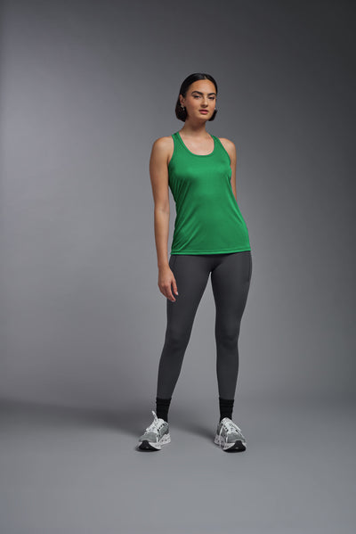 A female model with brown short hair on a gray background, wearing the Women's DrImax Endurance RacerbackTank in the color kelly green from a full body front view. This tank is made in the USA and is quick-drying and moisture-wicking. #color_kelly