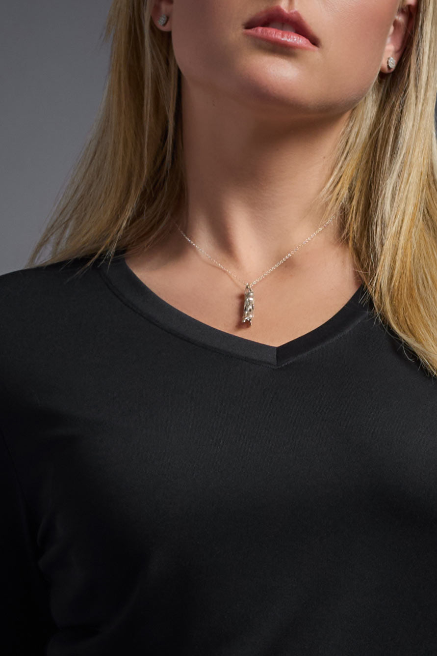 A blonde female model with long straight hair on a gray background, wearing the Women's DriMax™ V-neck Long Sleeve Expert Tee in the color black from a full body closeup collar view. This shirt is made in the USA and is quick-drying and moisture-wicking. #color_black