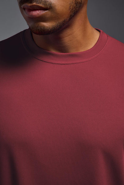 An African American male model with a beard on a gray background, wearing the Men's DriMax Expert Tee Shirt in the color cardinal from a collar closeup front view. This shirt is made in the USA and is quick-drying and moisture-wicking. #color_cardinal