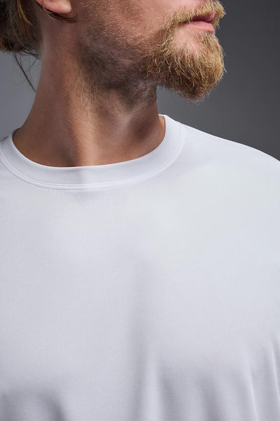 A blonde male model with a beard on a gray background, wearing the Men's DriMax Expert Tee Shirt in the color white from a close-up collar front view. This shirt is made in the USA and is quick-drying and moisture-wicking. #color_white