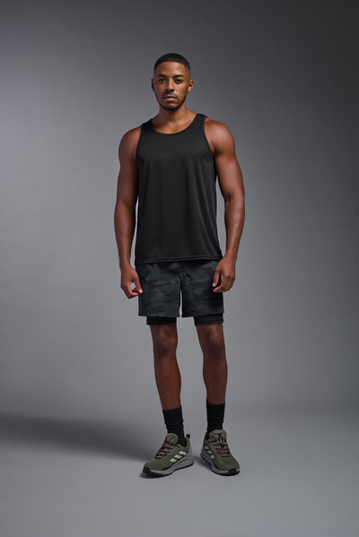 An African American male model with a beard on a gray background, wearing the Men's DriMax Endurance Tank in the color black from a full body front view. This shirt is made in the USA and is quick-drying and moisture-wicking. #color_black