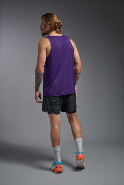 A blonde male model with a beard on a gray background, wearing the Men's DriMax Endurance Tank in the color dark purple from a full body back view. This shirt is made in the USA and is quick-drying and moisture-wicking. #color_dark-purple