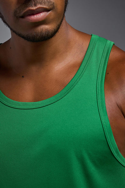 An African American male model with a beard on a gray background, wearing the Men's DriMax Endurance Tank in the color kelly greenfrom a closeup collar front view. This shirt is made in the USA and is quick-drying and moisture-wicking. #color_kelly-green
