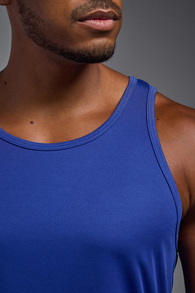 An African American male model with a beard on a gray background, wearing the Men's DriMax Endurance Tank in the color royal blue from a closeup collar front view. This shirt is made in the USA and is quick-drying and moisture-wicking. #color_royal-blue