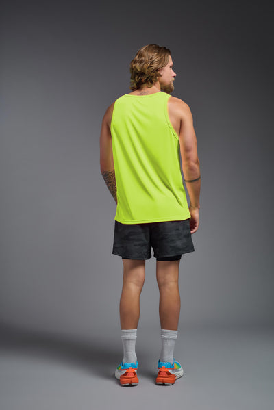 A blonde male model with a beard on a gray background, wearing the Men's DriMax Endurance Tank in the color safety yellow from a full body back view. This shirt is made in the USA and is quick-drying and moisture-wicking. #color_safety-yellow
