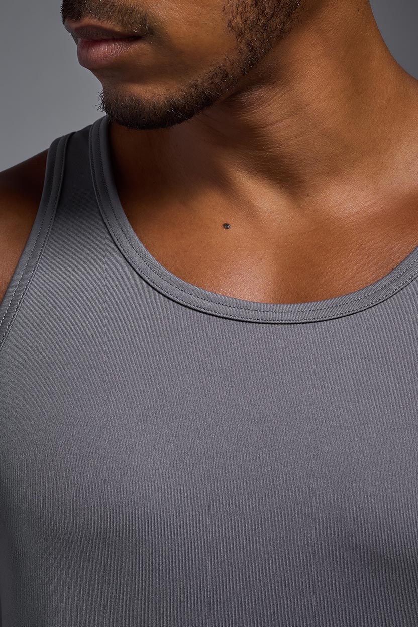 An African American male model with a beard on a gray background, wearing the Men's DriMax Endurance Tank in the color steel gray from a closeup collar front view. This shirt is made in the USA and is quick-drying and moisture-wicking. #color_steel