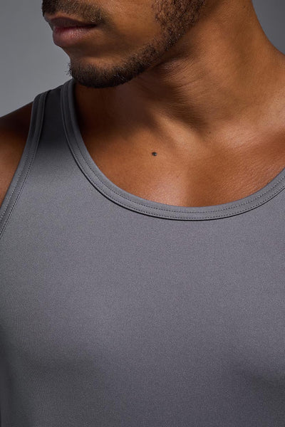 An African American male model with a beard on a gray background, wearing the Men's DriMax Endurance Tank in the color steel gray from a closeup collar front view. This shirt is made in the USA and is quick-drying and moisture-wicking. #color_steel