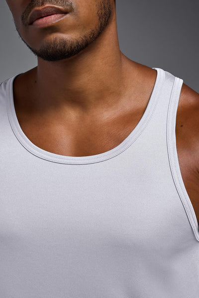 A blonde male model with a beard on a gray background, wearing the Men's DriMax Endurance from a closeup collar view. This shirt is made in the USA and is quick-drying and moisture-wicking. #color_white