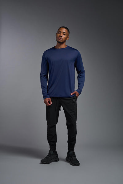 An African American male model with a beard on a gray background, wearing the Men's DriMax Long Sleeve Expert Shirt in the color navy from a full body front view. This shirt is made in the USA and is quick-drying and moisture-wicking. #color_navy