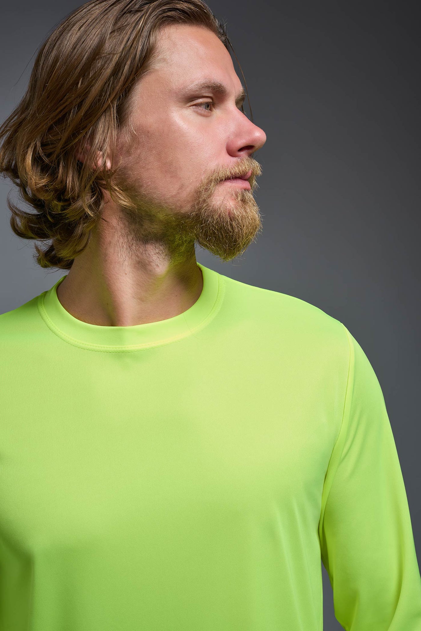 An African American male model with a beard on a gray background, wearing the Men's DriMax Long Sleeve Expert Shirt in the color safety yellow from a close-up collar view. This shirt is made in the USA and is quick-drying and moisture-wicking. #color_safety-yellow