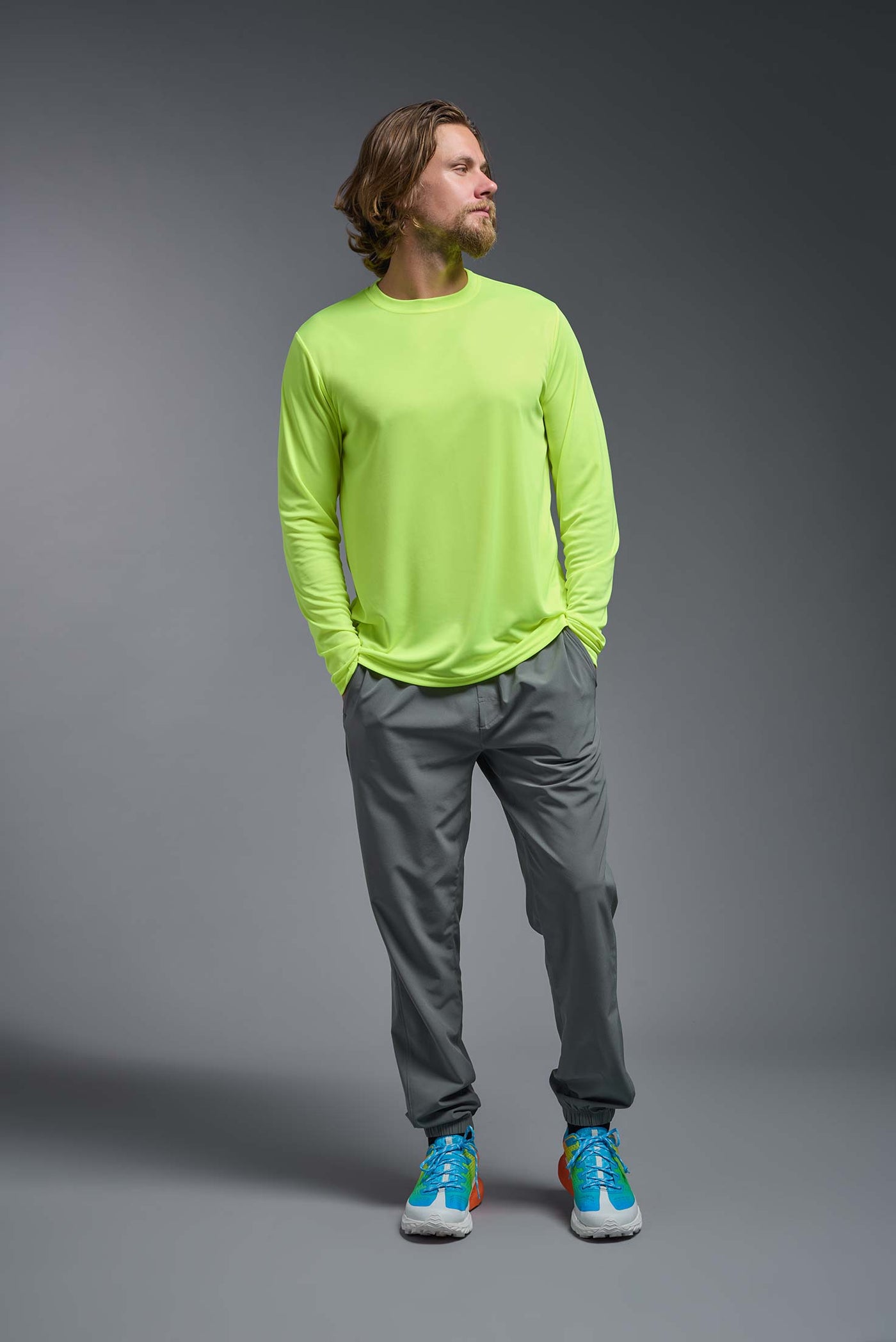 An African American male model with a beard on a gray background, wearing the Men's DriMax Long Sleeve Expert Shirt in the color safety yellow from a full body front view. This shirt is made in the USA and is quick-drying and moisture-wicking. #color_safety-yellow