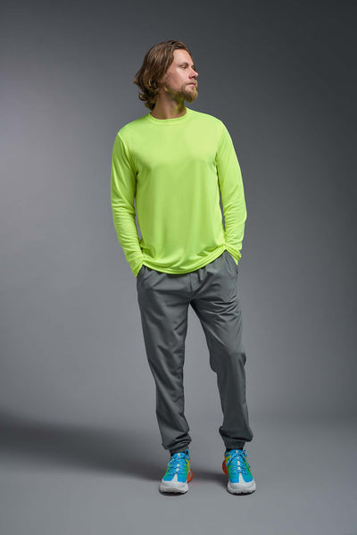 An African American male model with a beard on a gray background, wearing the Men's DriMax Long Sleeve Expert Shirt in the color safety yellow from a full body front view. This shirt is made in the USA and is quick-drying and moisture-wicking. #color_safety-yellow