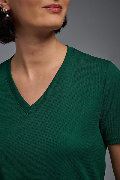 A female model with brown short hair on a gray background, wearing the Women's Oxymesh™ V-neck Tech Tee in the color forest green from a closeup collar front view. This shirt is made in the USA and is quick-drying and moisture-wicking. #color_forest-green