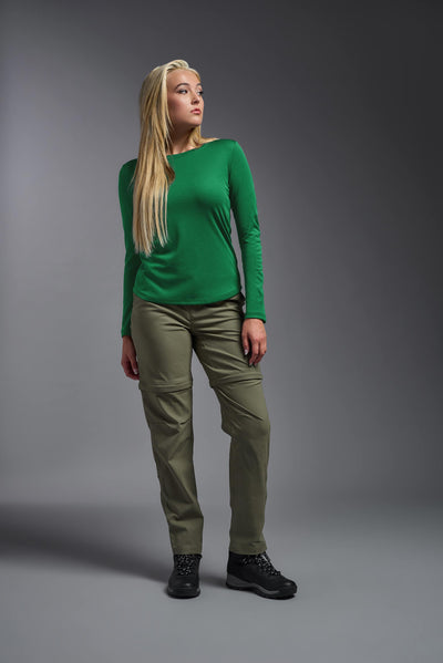 A blonde female model with long straight hair on a gray background, wearing the Women's Oxymesh™ Long Sleeve Tech Tee in the color kelly green from a full body front view. This shirt is made in the USA and is quick-drying and moisture-wicking. #color_kelly-green