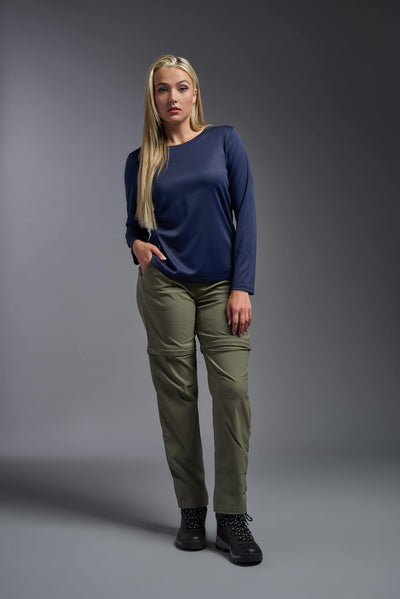 A blonde, female model with long straight hair on a gray background, wearing the Women's Oxymesh™ Long Sleeve Tech Tee in the color navy blue from a full body front view. This shirt is made in the USA and is quick-drying and moisture-wicking. #color_navy-blue