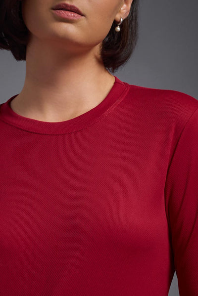 A female model with short brown hair on a gray background, wearing the Women's Oxymesh™ Long Sleeve Tech Tee in the color true red from a closeup collar front view. This shirt is made in the USA and is quick-drying and moisture-wicking. #color_true-red