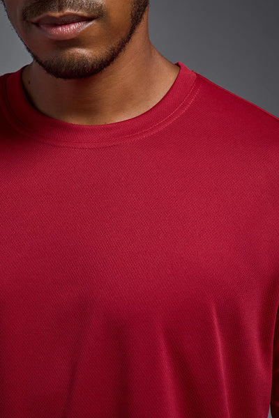 An African American male model with a beard on a gray background, wearing the Men's Oxymesh™ Crewneck Tech Tee in the color true red from a closeup collar front view. This shirt is made in the USA and is quick-drying and moisture-wicking. #color_true-red
