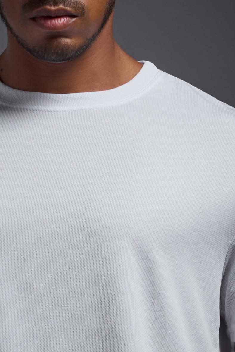 An African American male model with a beard on a gray background, wearing the Men's Oxymesh™ Crewneck Tech Tee in the color white from a closeup collar front view. This shirt is made in the USA and is quick-drying and moisture-wicking. #color_white