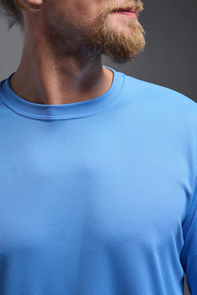 A blonde male model with a beard wearing the men's Oxymesh Long Sleeve Tech Tee in the color carolina blue on a gray background, made out of 100% polyester, showing the relaxed fit from a closeup collar front view. This shirt is breathable, quick-drying, moisture-wicking, and made in the USA. #color_carolina-blue