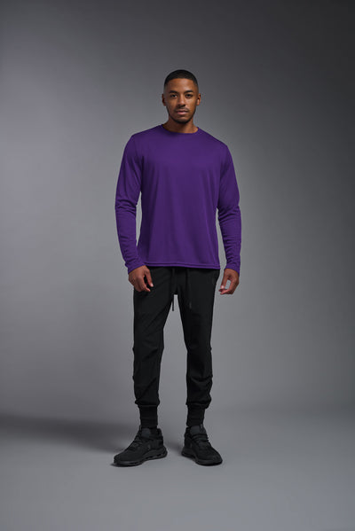An African American male model with a beard wearing the men's Oxymesh Long Sleeve Tech Tee in the color dark purple, made out of 100% polyester, showing the relaxed fit from a front view. This shirt is breathable, quick-drying, moisture-wicking, and made in the USA. #color_dark-purple