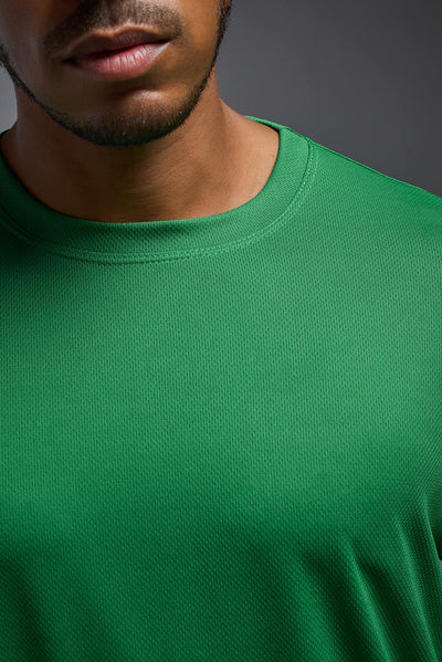 An African American male model with a beard wearing the men's Oxymesh Long Sleeve Tech Tee in the color kelly green on a gray background, made out of 100% polyester, showing the relaxed fit from a closeup collar front view. This shirt is breathable, quick-drying, moisture-wicking, and made in the USA. #color_kelly-green