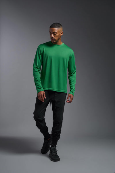 An African American male model with a beard wearing the men's Oxymesh Long Sleeve Tech Tee in the color kelly green on a gray background, made out of 100% polyester, showing the relaxed fit from a full body front view. This shirt is breathable, quick-drying, moisture-wicking, and made in the USA. #color_kelly-green