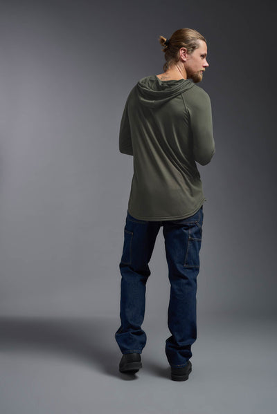 A blonde male model with a beard wearing the men's Siro Curvy Hoodie Shirt in the color olive, made out of 100% polyester, showing the relaxed fit from a back view. This hoodie shirt features a soft cotton feel, quick-dries, wicks moisture and is made in the USA. #color_olive