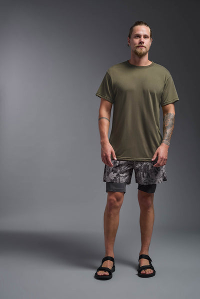 A male caucasian model with a beard wearing the men's DuroSoft Outdoor Tee in the color tan 499 on a gray background, made out of 100% filament polyester that feels like soft cotton, showing the modern fit from a front view. This shirt is anti-snagging, quick-drying and moisture-wicking and is made in the USA. #color_tan-499