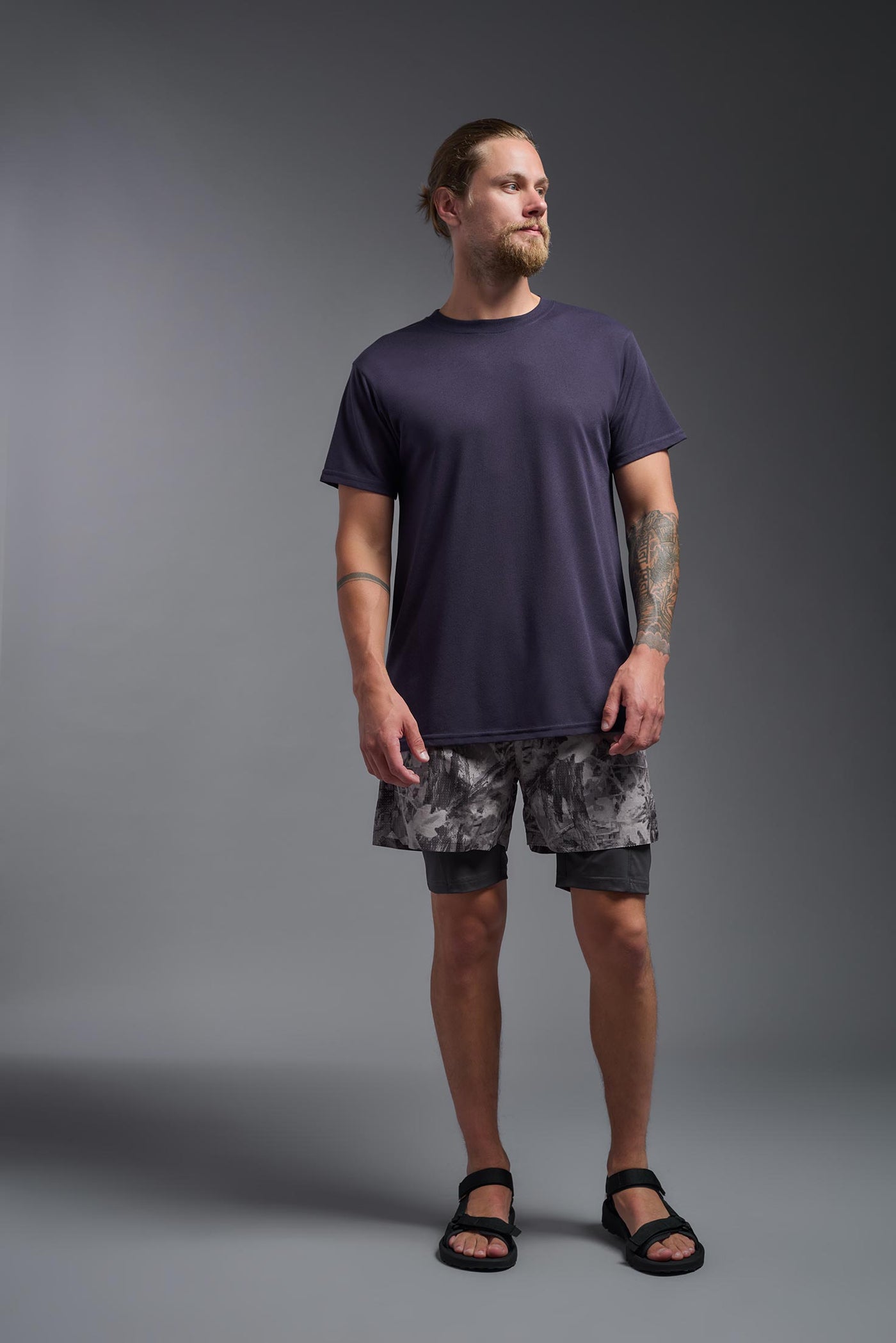 A male caucasian model with a beard wearing the men's DuroSoft Outdoor Tee in the color army blue on a gray background, made out of 100% filament polyester that feels like soft cotton, showing the modern fit from a front view. This shirt is anti-snagging, quick-drying and moisture-wicking and is made in the USA. #color_army-blue