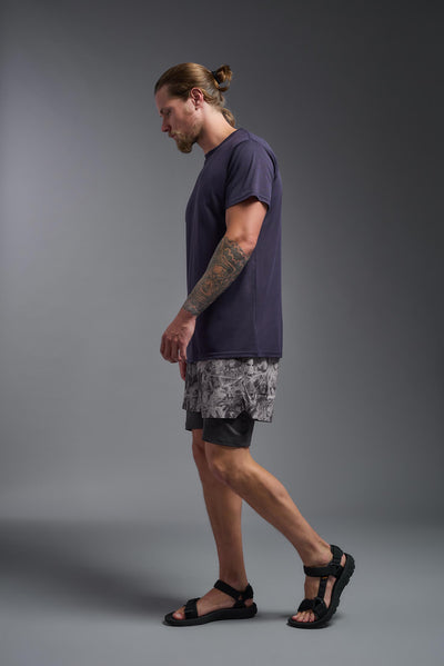 A male caucasian model with a beard wearing the men's DuroSoft Outdoor Tee in the color army blue on a gray background, made out of 100% filament polyester that feels like soft cotton, showing the modern fit from a side view. This shirt is anti-snagging, quick-drying and moisture-wicking and is made in the USA. #color_army-blue