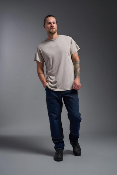 A male caucasian model with a beard wearing the men's DuroSoft Outdoor Tee in the color desert on a gray background, made out of 100% filament polyester that feels like soft cotton, showing the modern fit from a front view. This shirt is anti-snagging, quick-drying and moisture-wicking and is made in the USA. #color_desert