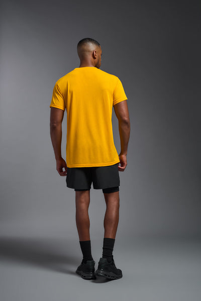 A male african-american model wearing the men's DuroSoft Outdoor Tee in the color yellow on a gray background, made out of 100% filament polyester that feels like soft cotton, showing the modern fit from a collar back view. This shirt is anti-snagging, quick-drying and moisture-wicking and is made in the USA. #color_yellow