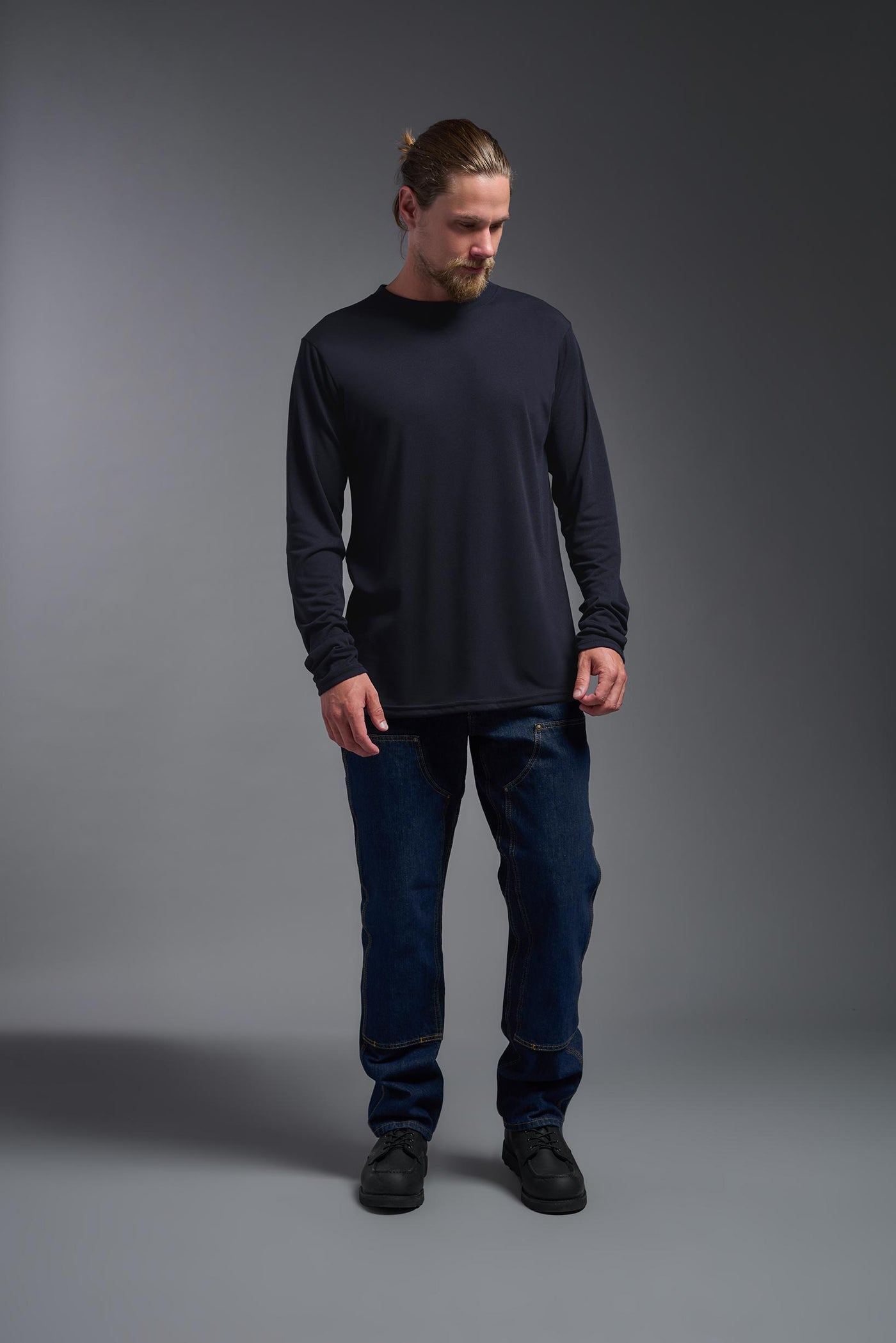 A male Caucasian model with a blonde hair and a beard wearing the men's DuroSoft Outdoor Long Sleeve in the color army blue on a gray background, made out of 100% filament polyester that feels like soft cotton, showing the modern fit from a front view. This shirt is anti-snagging, quick-drying and moisture-wicking and is made in the USA. #color_army-blue