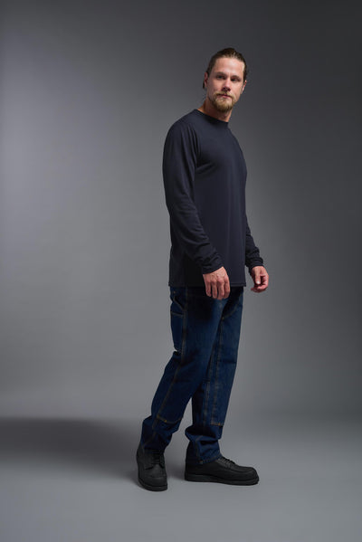 A male Caucasian model with a blonde hair and a beard wearing the men's DuroSoft Outdoor Long Sleeve in the color army blue on a gray background, made out of 100% filament polyester that feels like soft cotton, showing the modern fit from a side view. This shirt is anti-snagging, quick-drying and moisture-wicking and is made in the USA. #color_army-blue