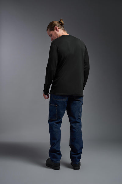 A male Caucasian model with a blonde hair and a beard wearing the men's DuroSoft Outdoor Long Sleeve in the color black on a gray background, made out of 100% filament polyester that feels like soft cotton, showing the modern fit from a back view. This shirt is anti-snagging, quick-drying and moisture-wicking and is made in the USA. #color_black