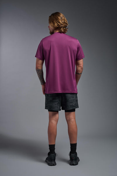 A blonde, male model with a beard wearing the men's EcoTek™ Recycled Performance Tee in the color merlot, made out of 100% recycled polyester REPREVE®, showing the modern fit from a back view. This shirt features a mechanical stretch, quick-dries, wicks moisture and is made in the USA. #color_merlot