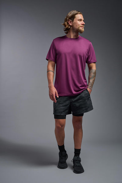 A blonde, male model with a beard wearing the men's EcoTek™ Recycled Performance Tee in the color merlot, made out of 100% recycled polyester REPREVE®, showing the modern fit from a front view. This shirt features a mechanical stretch, quick-dries, wicks moisture and is made in the USA. #color_merlot