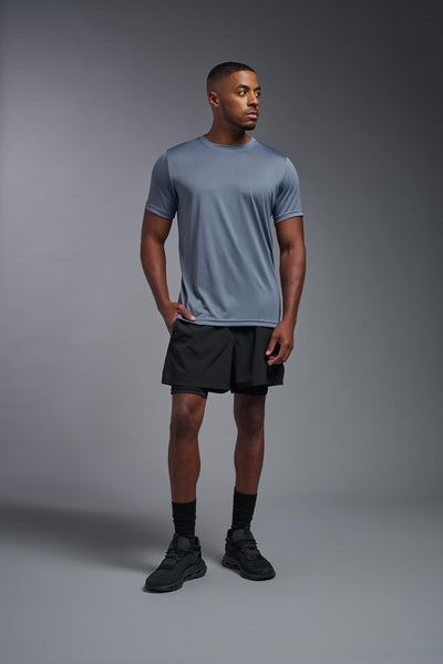 An African American, male model with a beard wearing the men's EcoTek™ Recycled Performance Tee in the color tahoe blue, made out of 100% recycled polyester REPREVE®, showing the modern fit from a front view. This shirt features a mechanical stretch, quick-dries, wicks moisture and is made in the USA. #color_tahoe