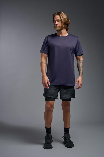 A blonde, male model with a beard wearing the men's EcoTek™ Recycled Performance Tee in the color twilight, made out of 100% recycled polyester REPREVE®, showing the modern fit from a front view. This shirt features a mechanical stretch, quick-dries, wicks moisture and is made in the USA. #color_twilight