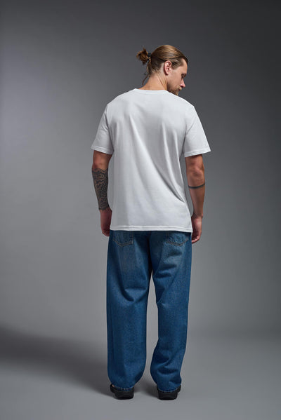 A male model wearing the unisex Organic Soft Cotton T-shirt in the color white, made from 100% certified organic cotton, shot from a full body back view. This shirt is unisex and made in the USA. #color_white