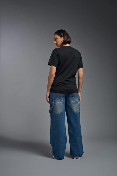 A female model wearing the unisex Organic Soft Cotton T-shirt in the color black, made from 100% certified organic cotton, shot from a full body back view. This shirt is unisex and made in the USA. #color_black
