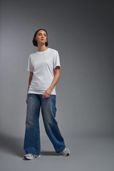 A female model wearing the unisex Organic Soft Cotton T-shirt in the color white, made from 100% certified organic cotton, shot from a full body front view. This shirt is unisex and made in the USA. #color_white