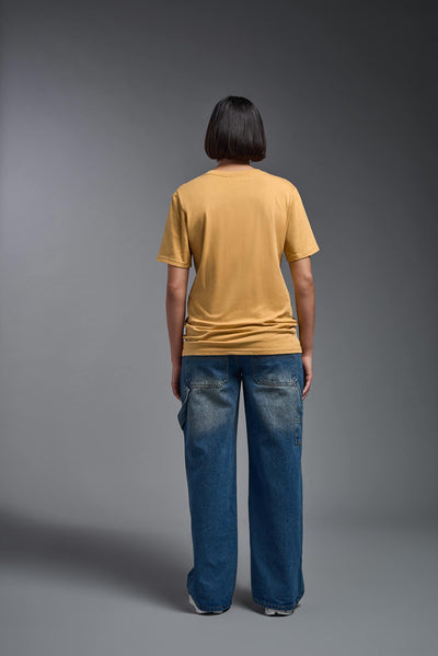 A female model wearing the unisex Organic Soft Cotton T-shirt in the color harvest, made from 100% certified organic cotton, shot from a full body back view. This shirt is unisex and made in the USA. #color_harvest